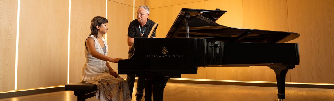 Female student playing a Steinway piano in the conservatoire auditorium in the East Quad