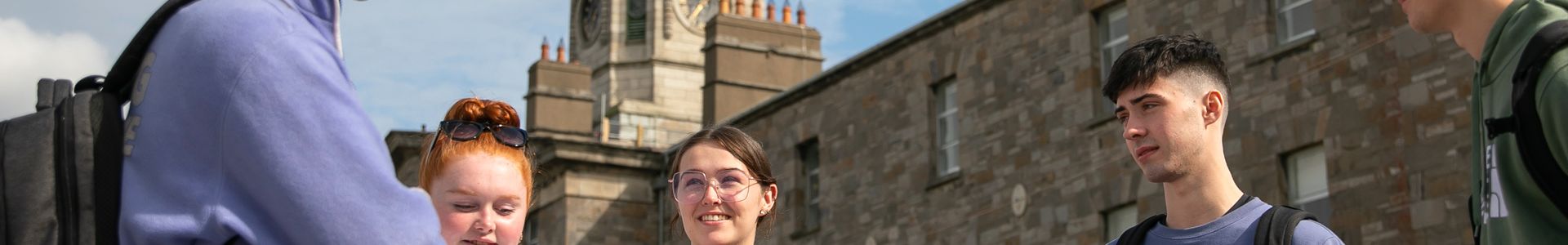 Students standing talking outside the clocktower on the Grangegorman campus