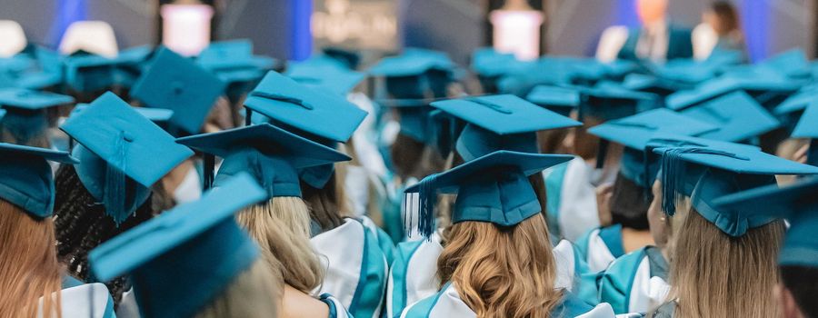 graduates wearing graduation hats at ceremony