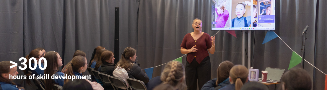 A women speaks in front of a group of secondary school aged girls