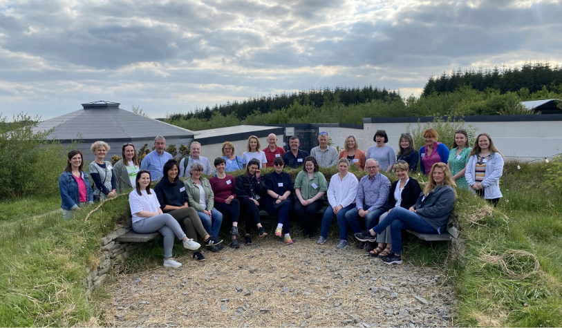 Large group of people in semi circle-half sitting half standing-outdoors
