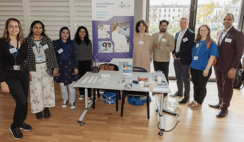 six researchers from Nanolab Research lab at a exhibit table