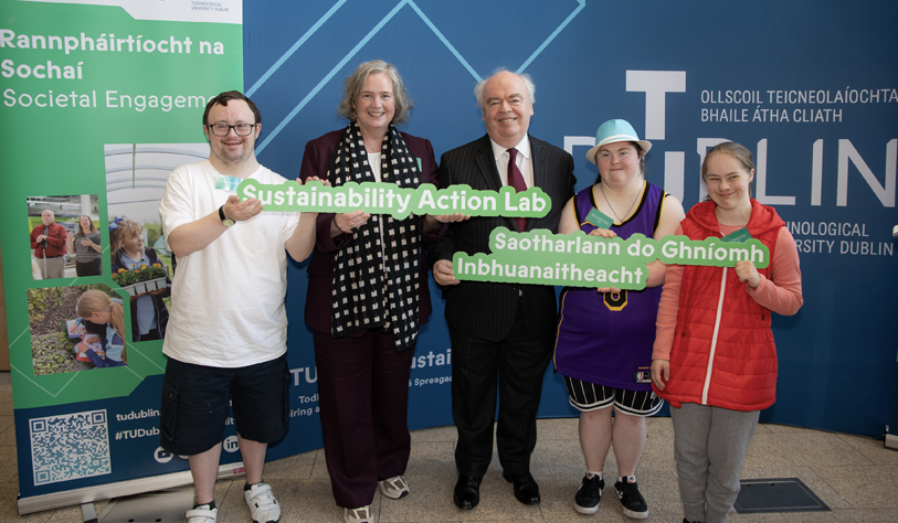 Five white people holding a sign saying Sustainability action Lab IN ENGLISH and irish, three young adult learners and two older university staff
