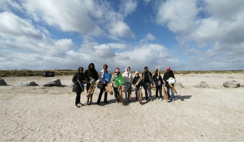 9 people gather on beach for beach clean holding hessian bags