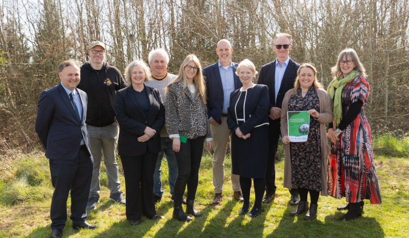 five white women and five white men smile for camera in outdoor setting
