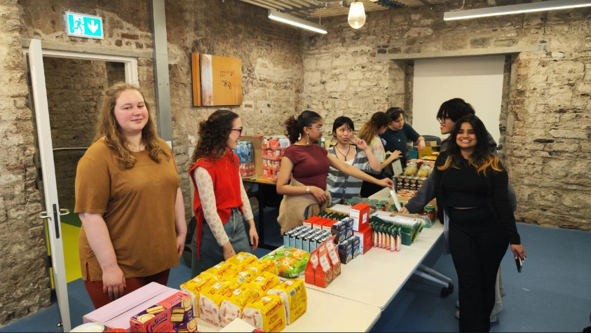 Group of volunteers stand behind table of food