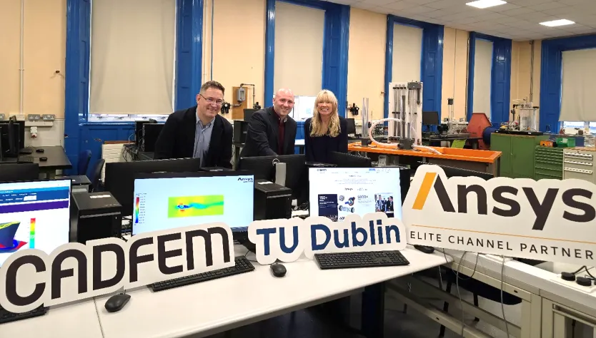 An image of three people standing among computers in a lab