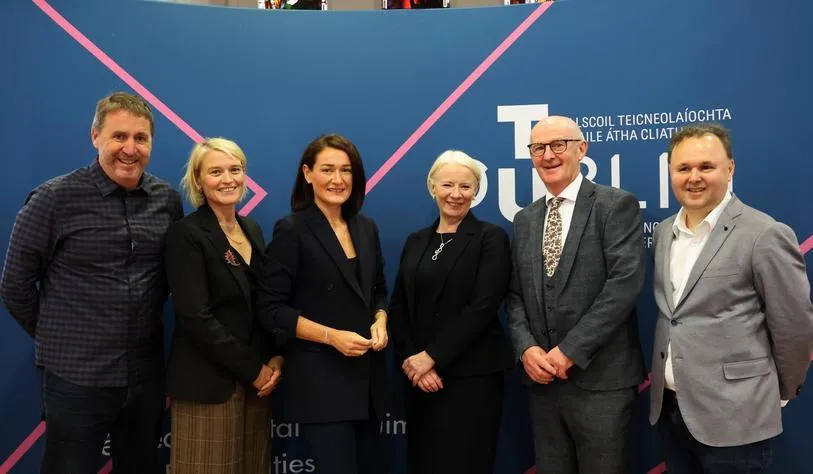 Group of six people standing together at TU Dublin’s Tallaght Campus, posing for a photograph in front of a TU Dublin branded backdrop.