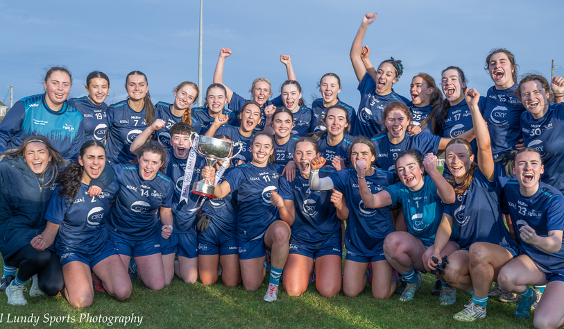 Two people in sporting clothing celebrate on a grass field