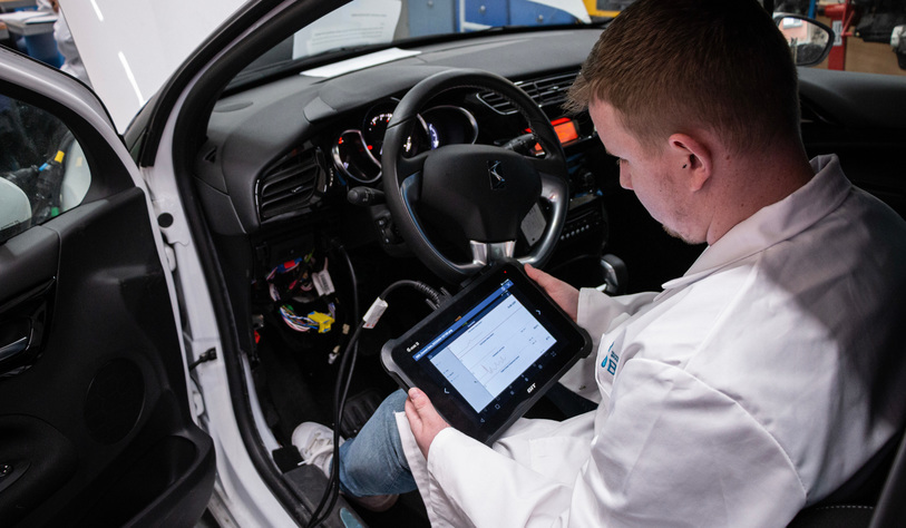 Apprentice using a tablet in a car