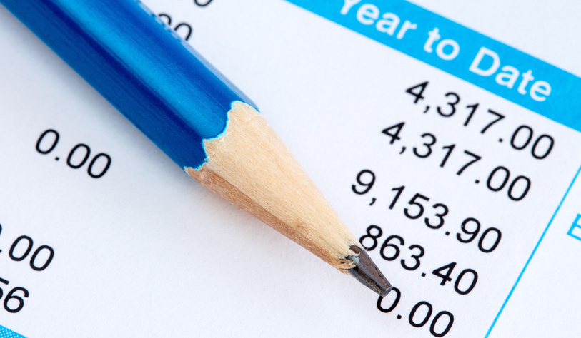 An image of a pencil and a wage slip