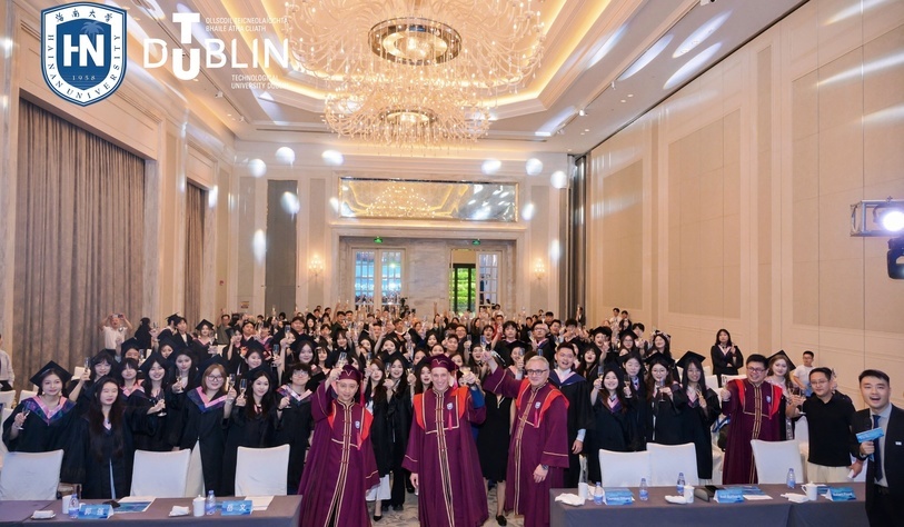 A group photo at a graduation ceremony is a palatial room with chandeliers