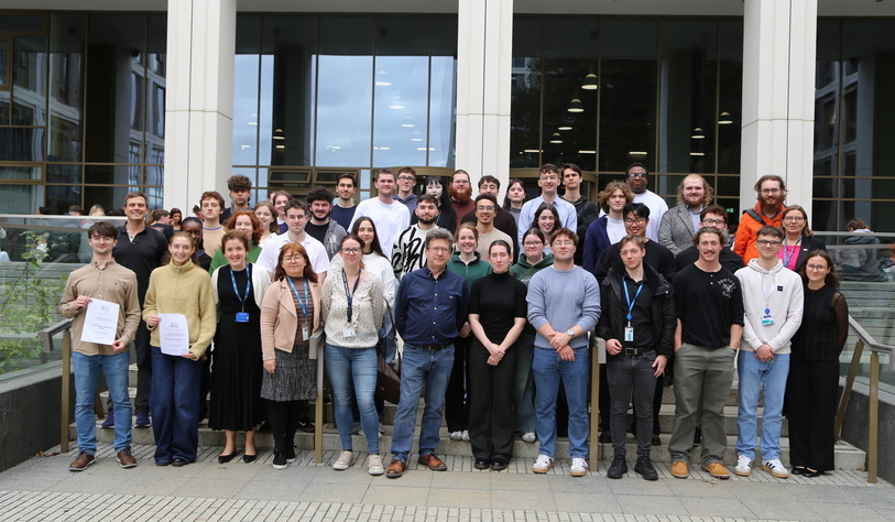 A group of people pose outside the Central Quad an event