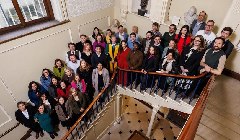 A group of people on a stairwell looking up to a camera