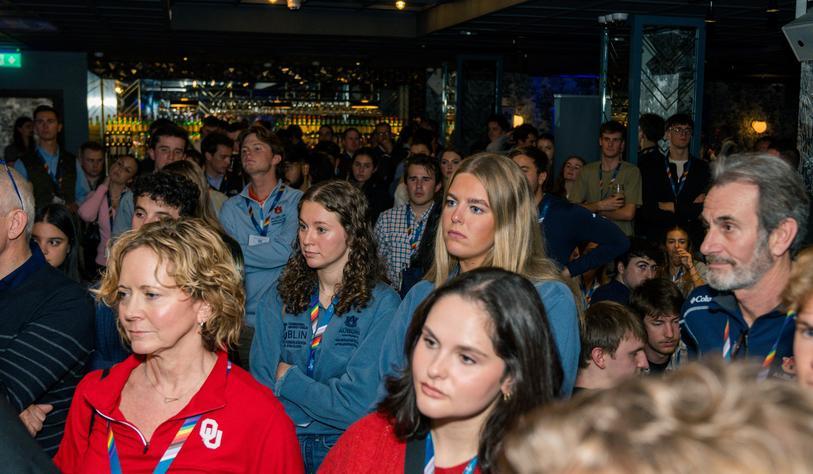 A crowd of people listen to a speaker