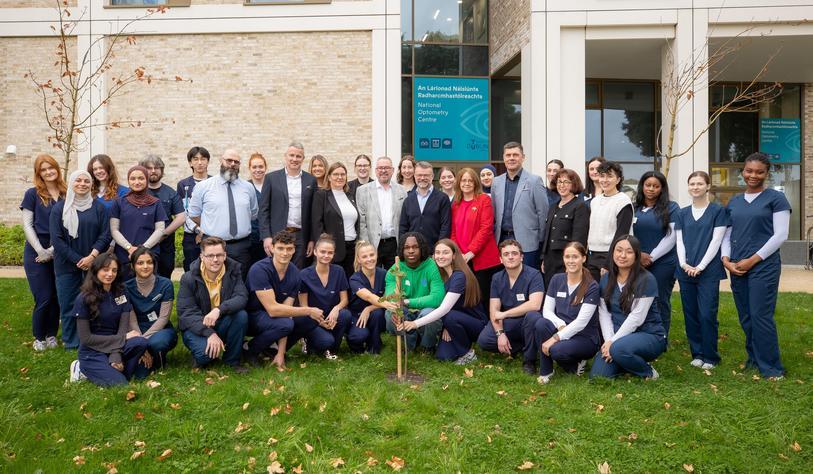 A group of people posing with a Sycamore Tree