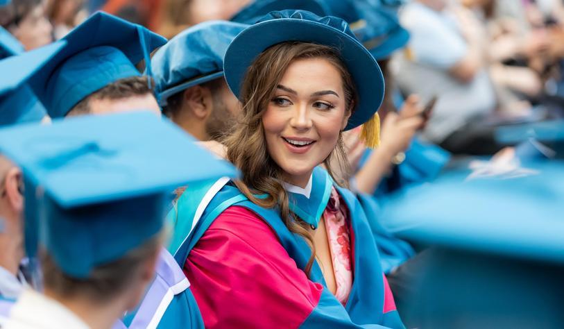 Graduates in formal conferring robes of cyan