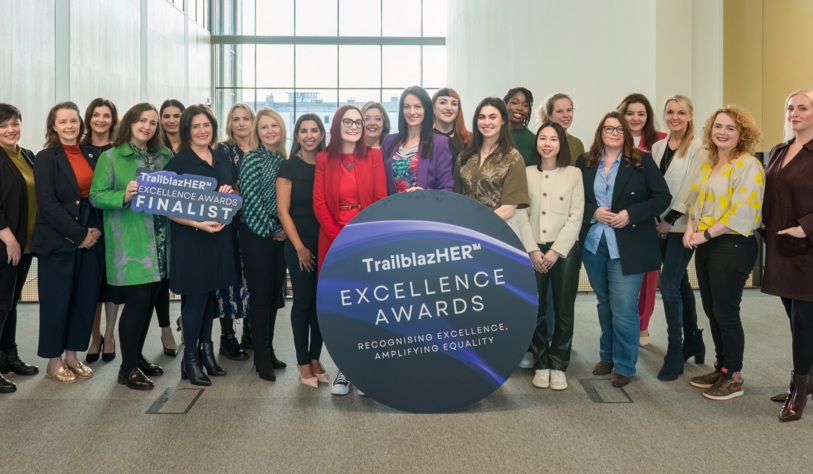 A group of people pose with a banner that says TrailBlazHer Awards