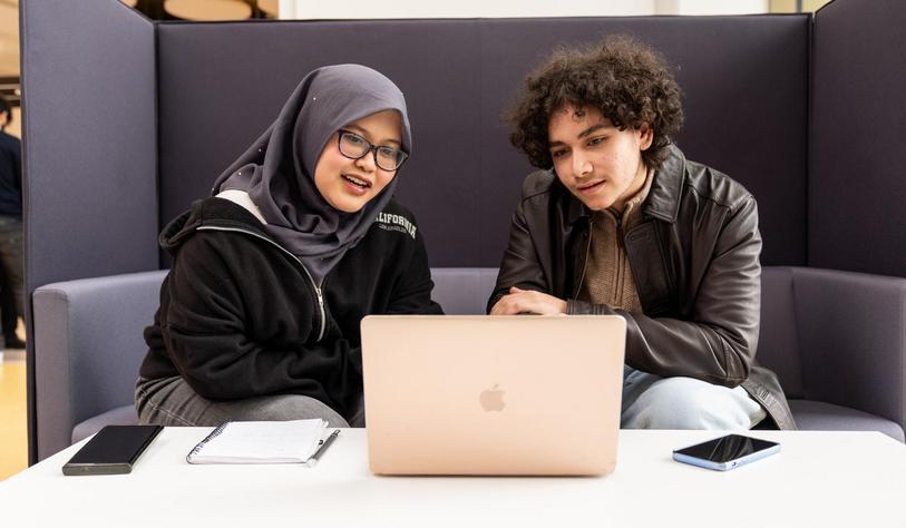 Students work together with a laptop