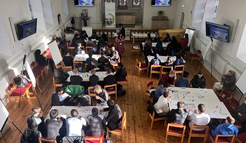 An overhead view of students working in groups during the Future of Food workshop, with presenters and facilitators supporting the activities.