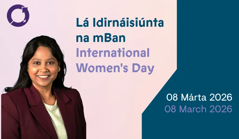 Woman smiling in front of a light pink and teal background. Text reads “Lá Idirnáisiúnta na mBan, International Women's Day, 08 Márta 2026, 08 March 2026.”